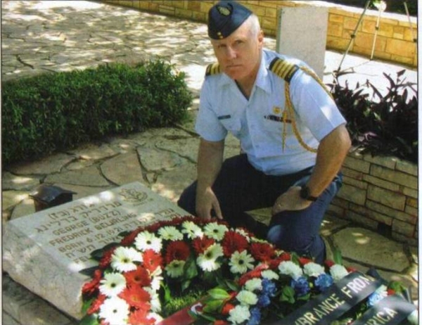 Col Pat Dennis, then Canadian Defence Attaché in Israel, kneels at the grave of F/O Beurling in the Haifa Military Cemetery in Israel.
